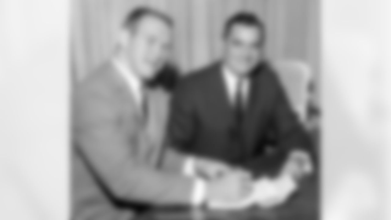 FILE - In this Dec. 14, 1965, file photo, All-America Texas linebacker Tommy Nobis, left, and Rankin Smith, owner of the Atlanta Falcons of the National Football League announce Nobis' signing of a contract with the team in Austin, Texas on Dec. 14, 1965. Nobis, the first player ever drafted by Atlanta in 1966 and a hard-hitting linebacker who went on to spent his entire 11-year career with the team, died Wednesday, Dec. 13, 2017, after an extended illness, the team announced. He was 74.
 (AP Photo/File)