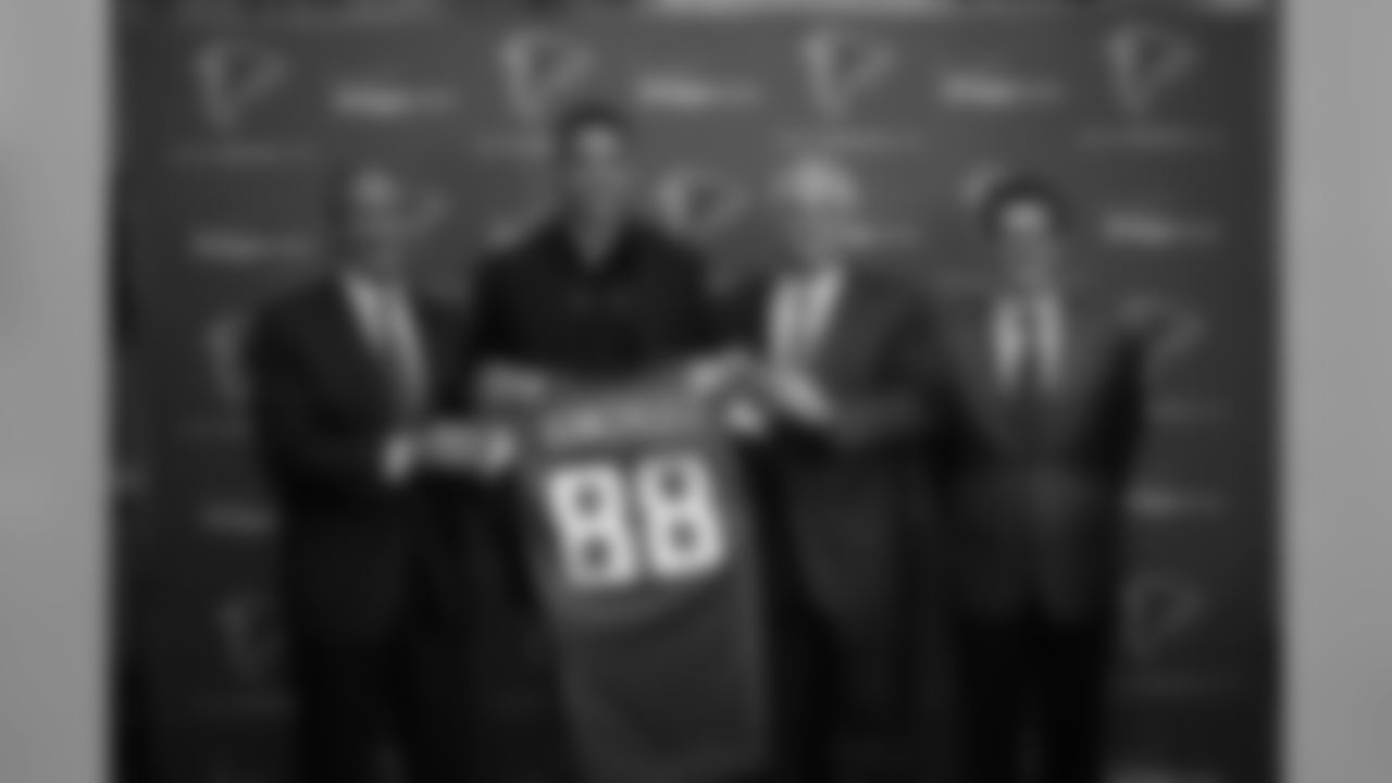 Tony Gonzalez holds up his new jersey alongside Falcons owner and chairman Arthur Blank, head coach Mike Smith and general manager Thomas Dimitroff.