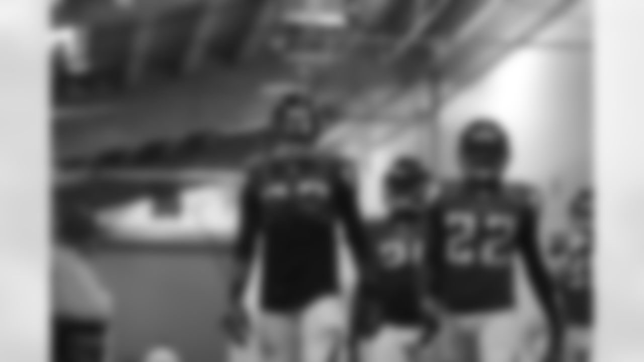 Defensive backs walk towards the field