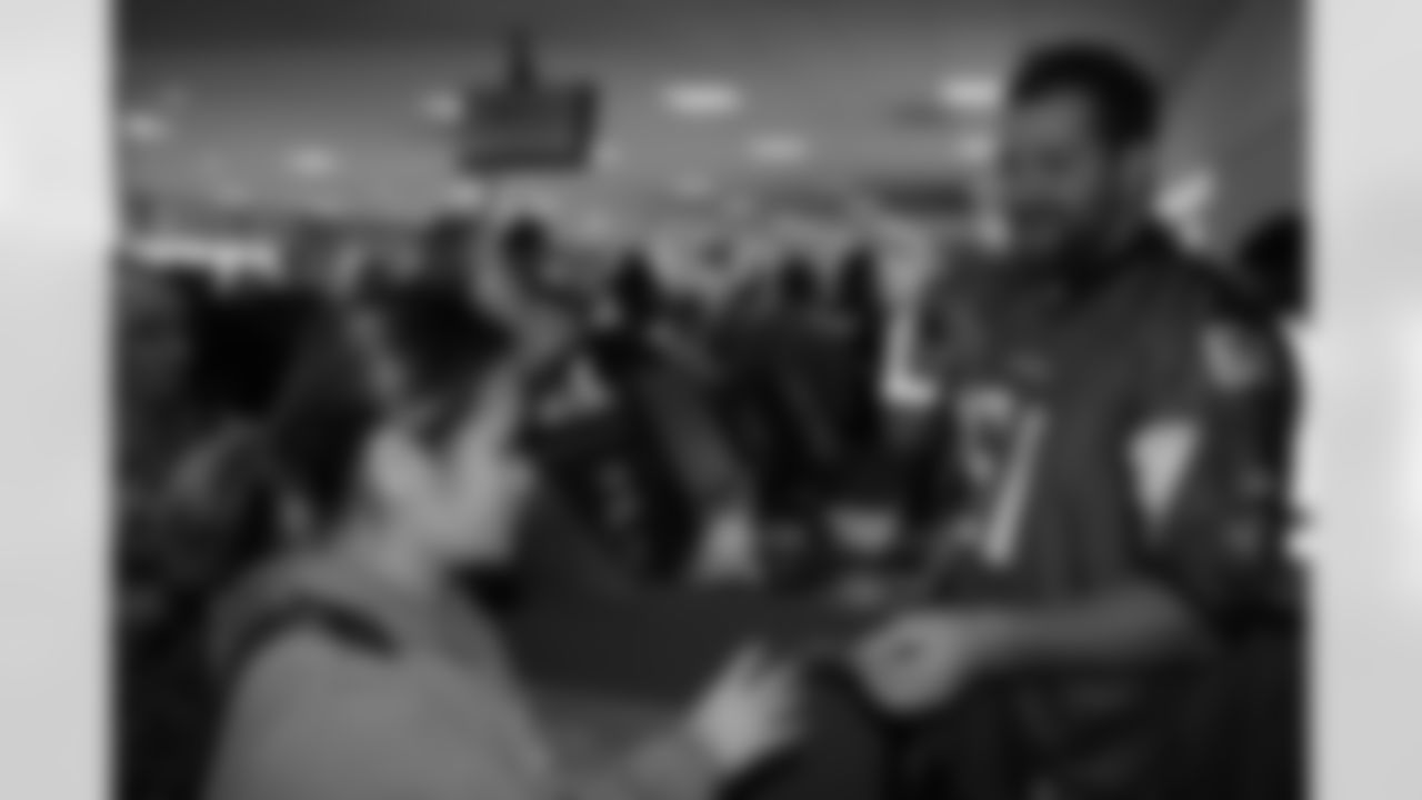 Several Falcons traded places with AirTran workers to marshal planes, take tickets and greet passengers // Trading Places - AirTran // Nov. 1, 2011 // Atlanta -