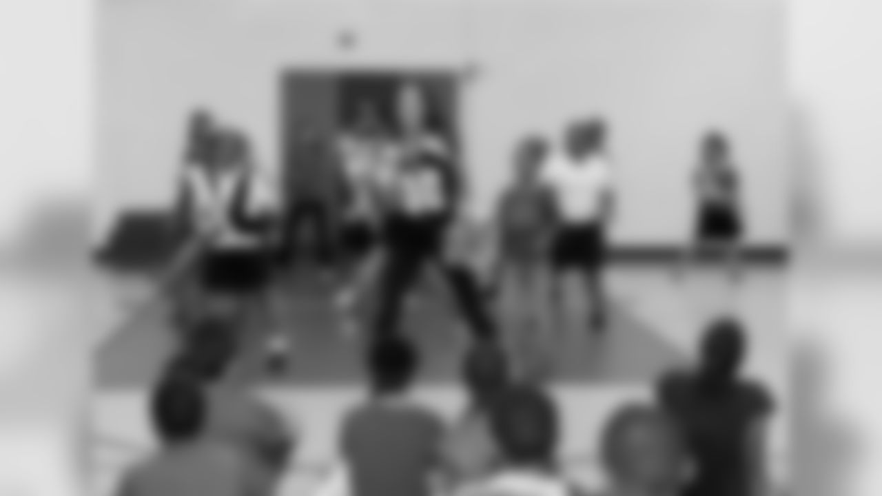 Falcons Cheerleader teaches a dance to students.
