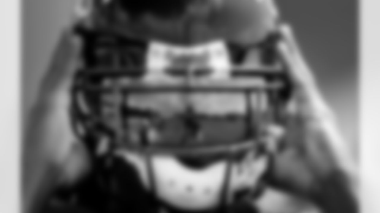 Atlanta Falcons' Steven Jackson, left, and Julio Jones, are reflected in the visor of teammate Roddy White as he puts his helmet on during training camp