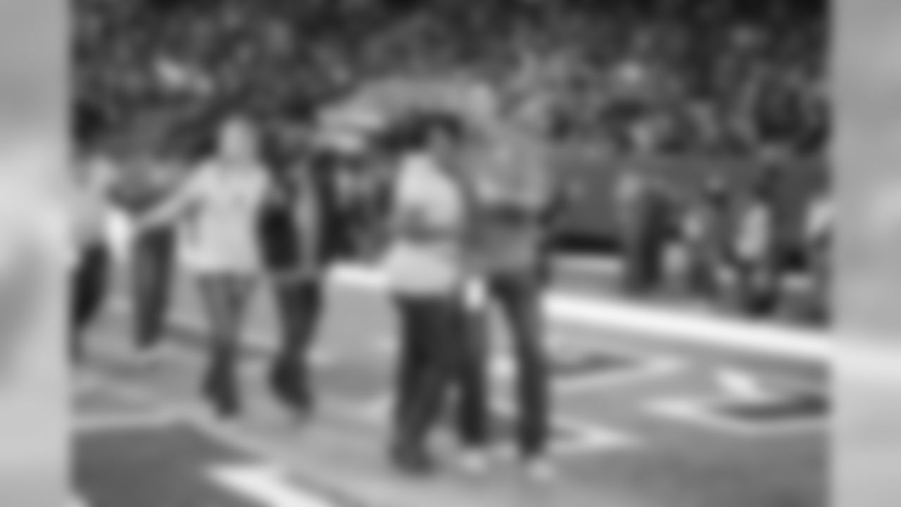 Breast cancer survivors received pink roses and were escorted out of the tunnel onto the field by Falcons alumni