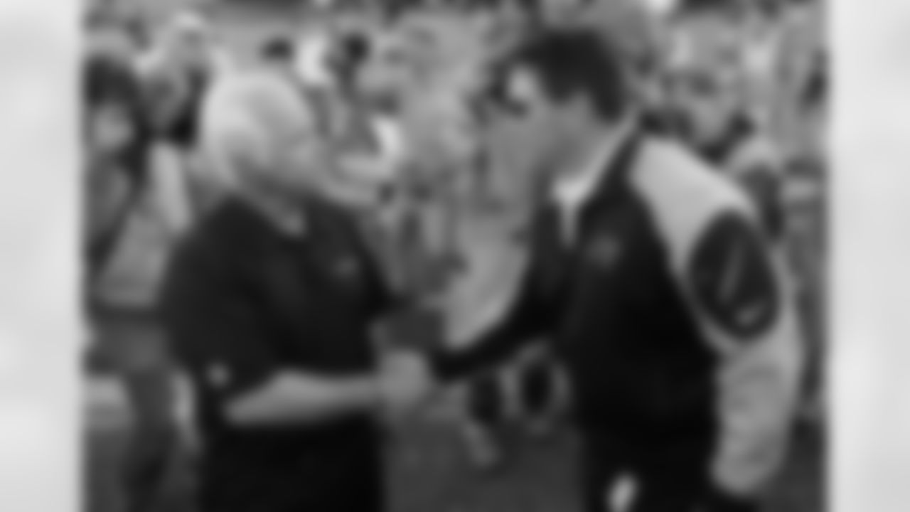 Head coach Mike Smith shakes hands with Panthers head coach Ron Rivera