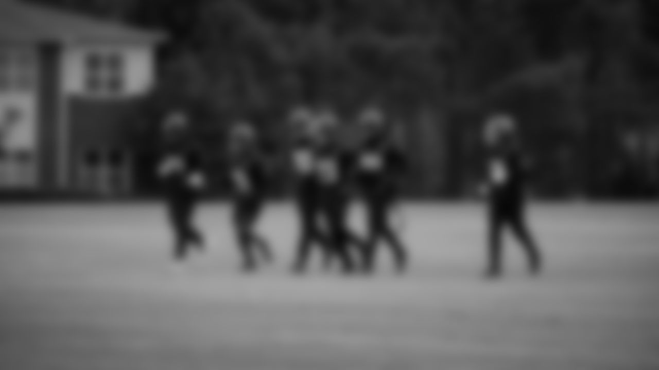 The running backs jog during practice at IBM Performance Field.