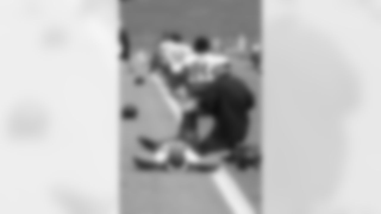 DE Osi Umenyiora stretches before practice
