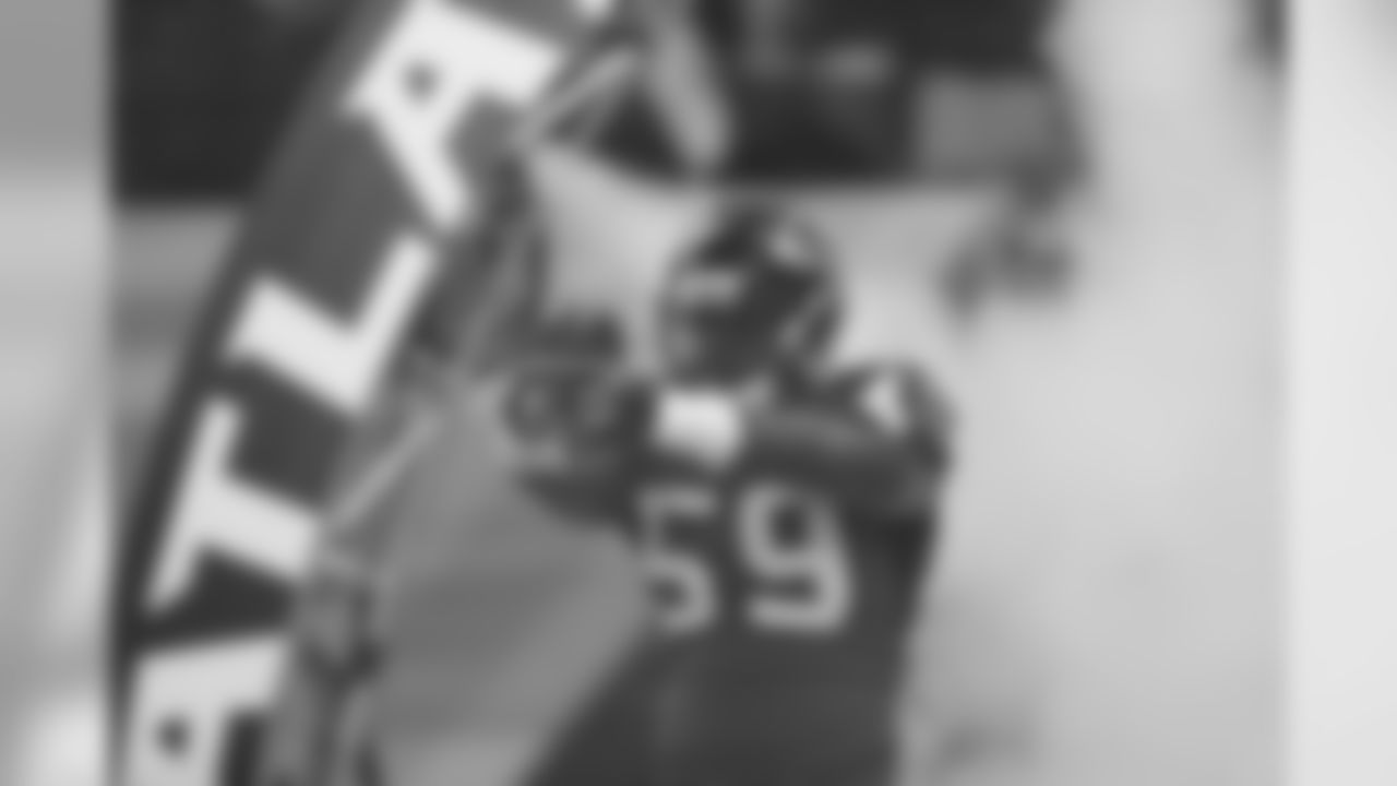 LB Joplo Bartu breaks through the smoke during introductions