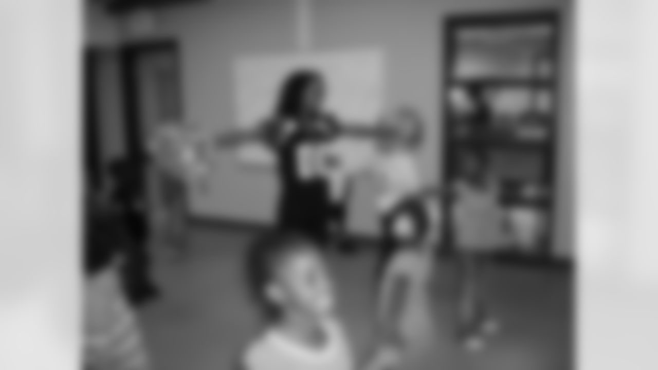 Cheerleader Joie dances with kids at Centennial Place YMCA, which was renam