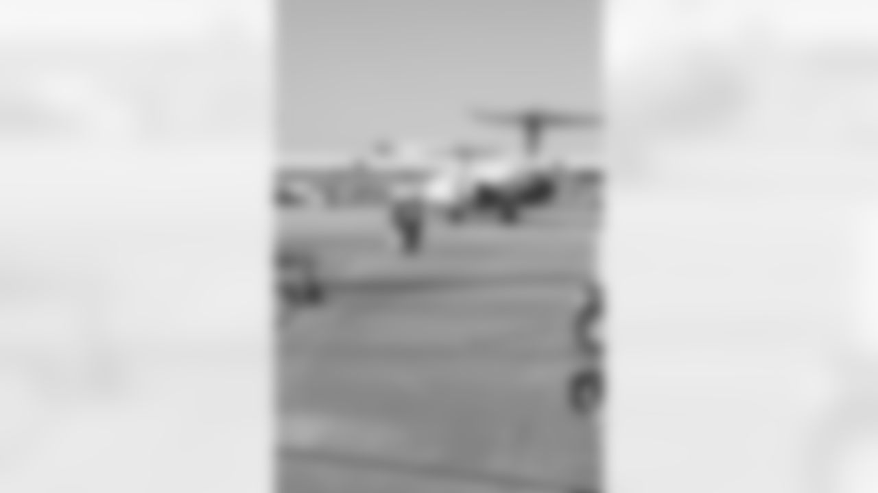 Several Falcons traded places with AirTran workers to marshal planes, take tickets and greet passengers // Trading Places - AirTran // Nov. 1, 2011 // Atlanta -