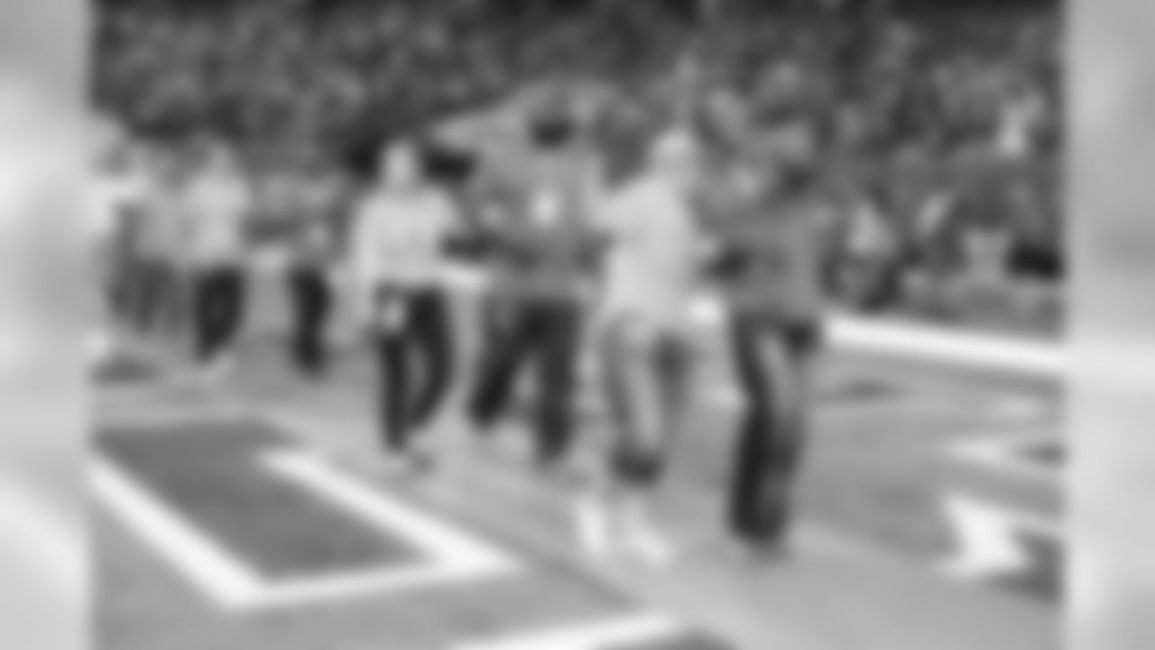 Breast cancer survivors received pink roses and were escorted out of the tunnel onto the field by Falcons alumni
