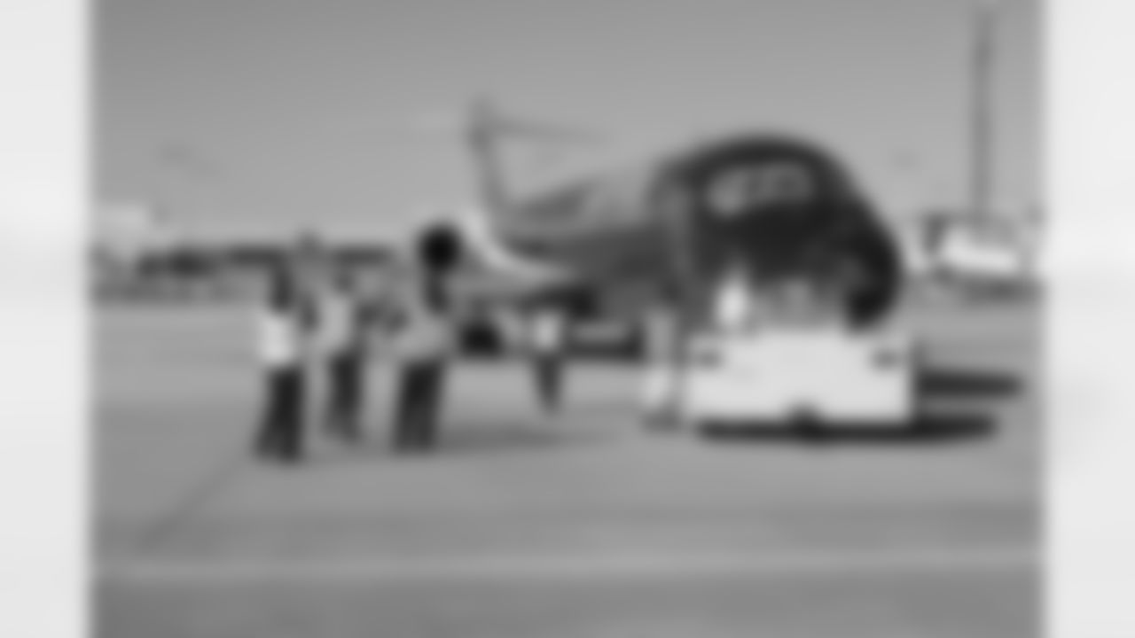 Several Falcons traded places with AirTran workers to marshal planes, take tickets and greet passengers // Trading Places - AirTran // Nov. 1, 2011 // Atlanta -