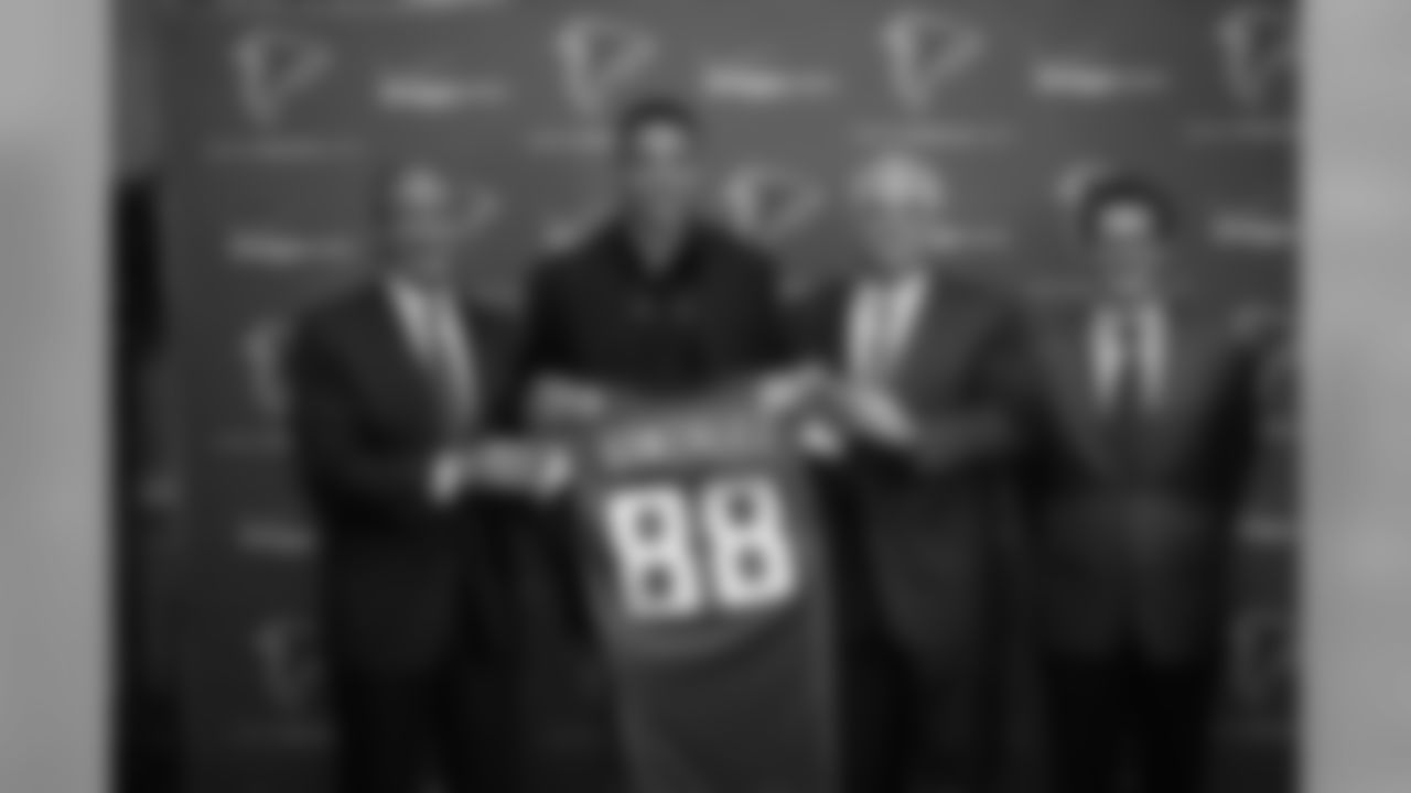 Tony Gonzalez holds up his new jersey alongside Falcons owner and chairman Arthur Blank, head coach Mike Smith and general manager Thomas Dimitroff.