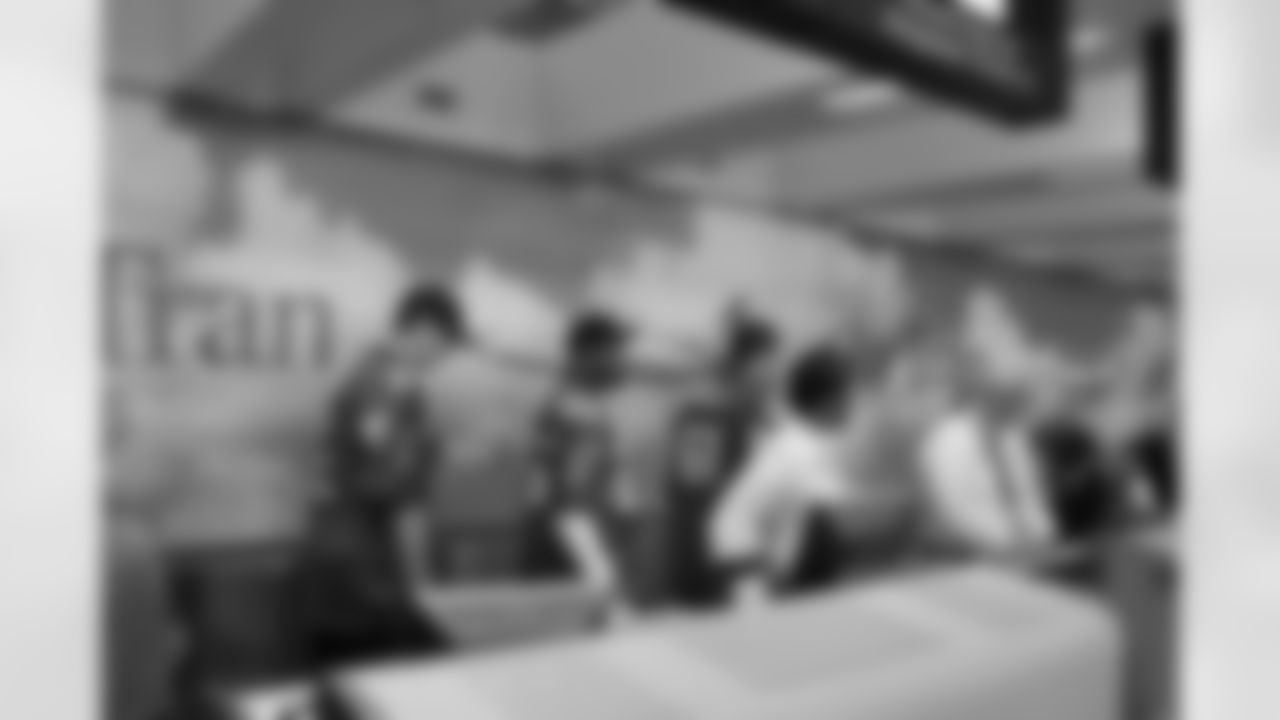 Several Falcons traded places with AirTran workers to marshal planes, take tickets and greet passengers // Trading Places - AirTran // Nov. 1, 2011 // Atlanta -