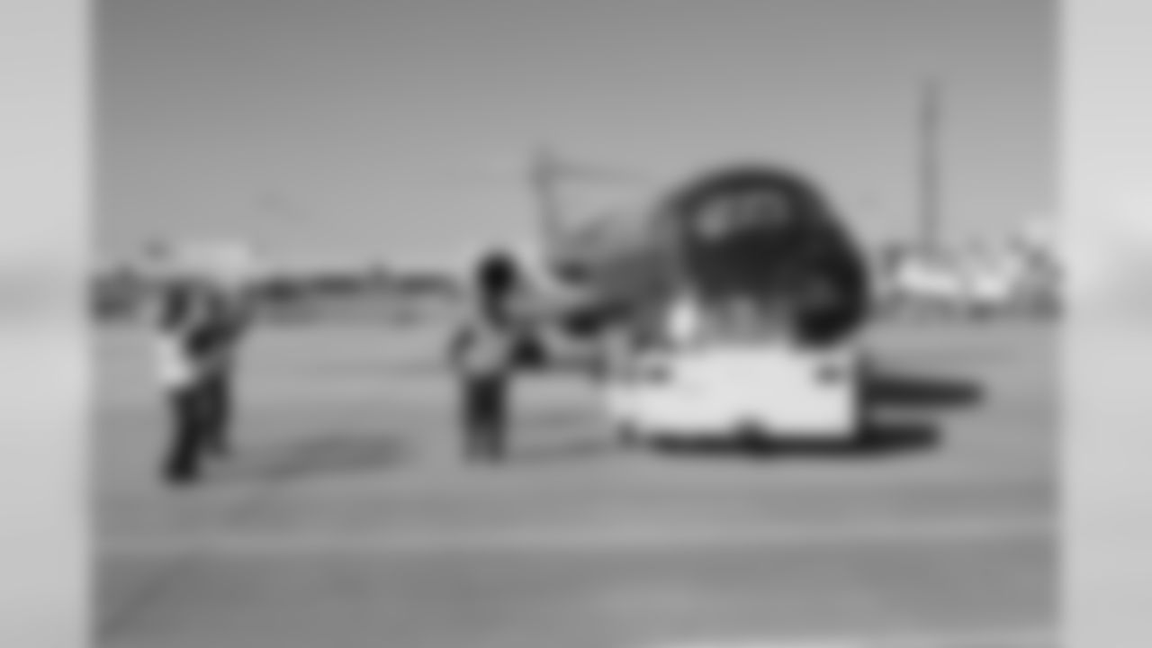 Several Falcons traded places with AirTran workers to marshal planes, take tickets and greet passengers // Trading Places - AirTran // Nov. 1, 2011 // Atlanta -