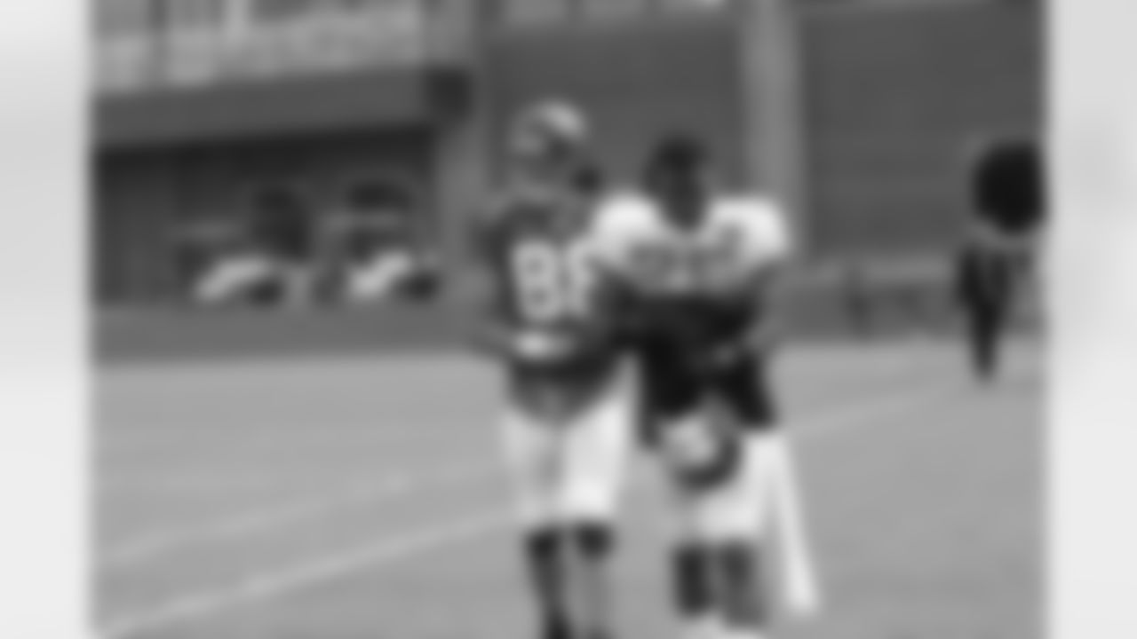 TE Tony Gonzalez and S William Moore walk onto the practice field