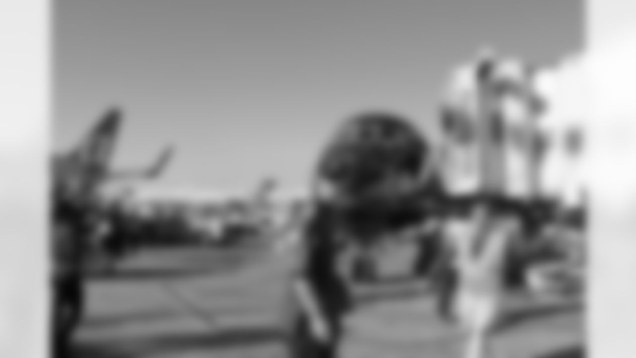 Several Falcons traded places with AirTran workers to marshal planes, take tickets and greet passengers // Trading Places - AirTran // Nov. 1, 2011 // Atlanta -