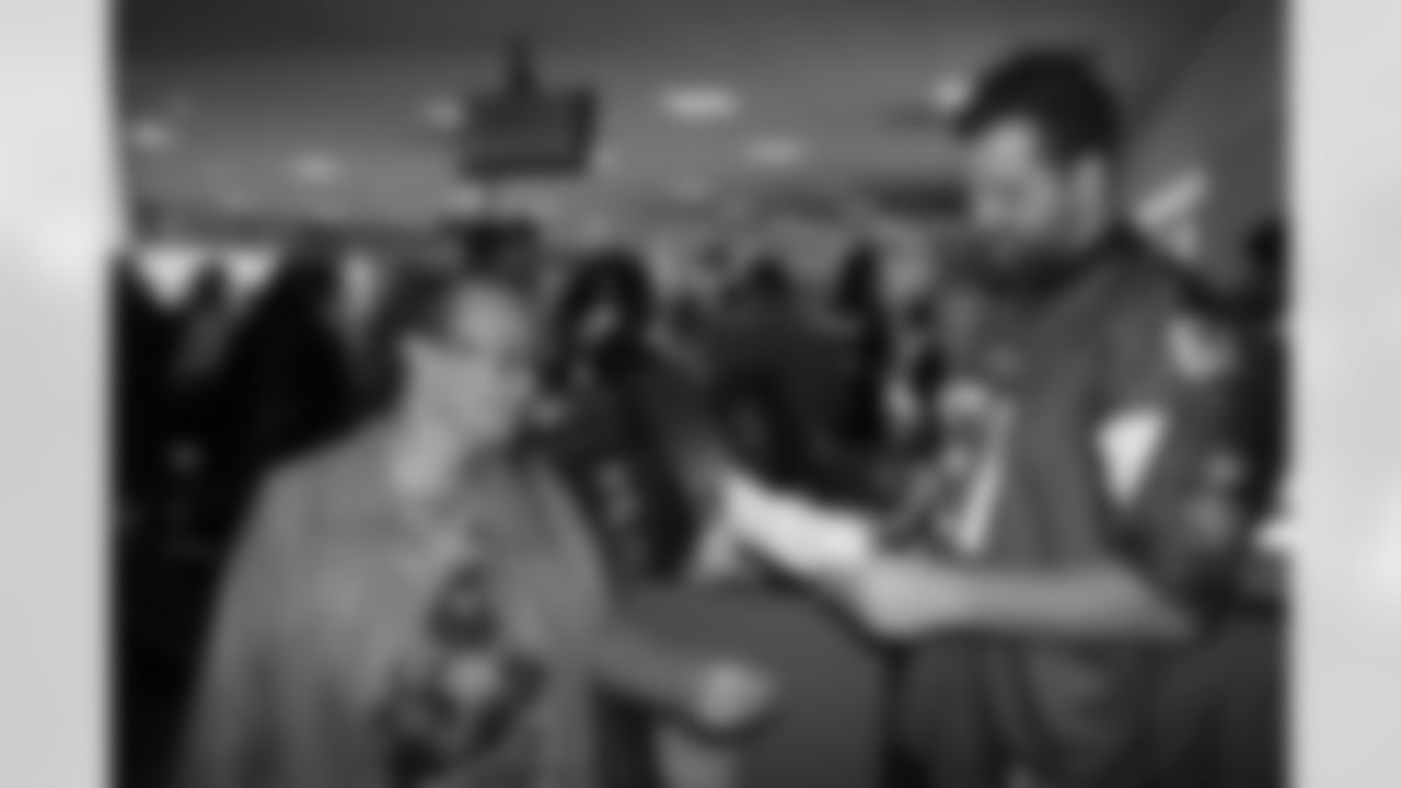 Several Falcons traded places with AirTran workers to marshal planes, take tickets and greet passengers // Trading Places - AirTran // Nov. 1, 2011 // Atlanta -