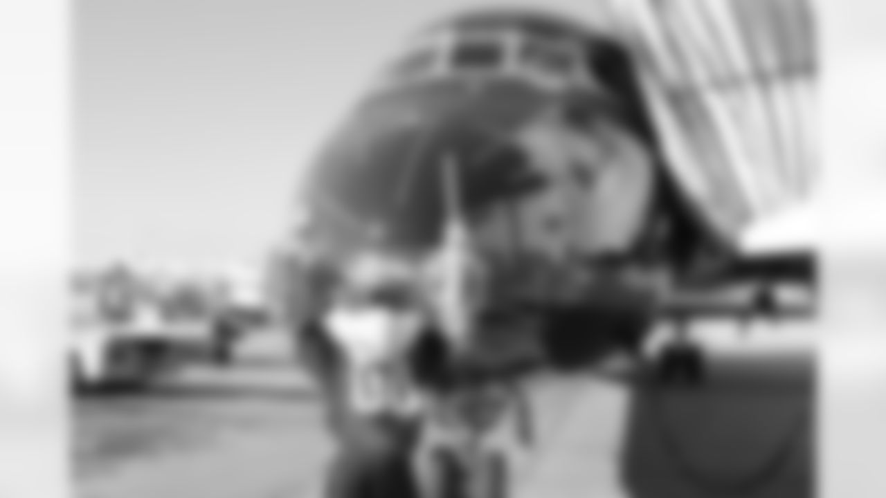 Several Falcons traded places with AirTran workers to marshal planes, take tickets and greet passengers // Trading Places - AirTran // Nov. 1, 2011 // Atlanta -