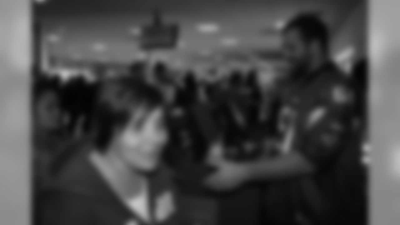 Several Falcons traded places with AirTran workers to marshal planes, take tickets and greet passengers // Trading Places - AirTran // Nov. 1, 2011 // Atlanta -