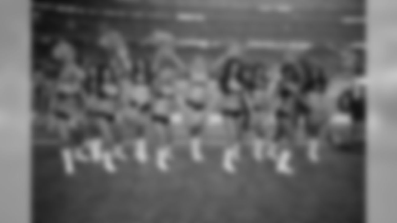 Many of the Atlanta Falcons Cheerleaders pose for a picture on the sidelines