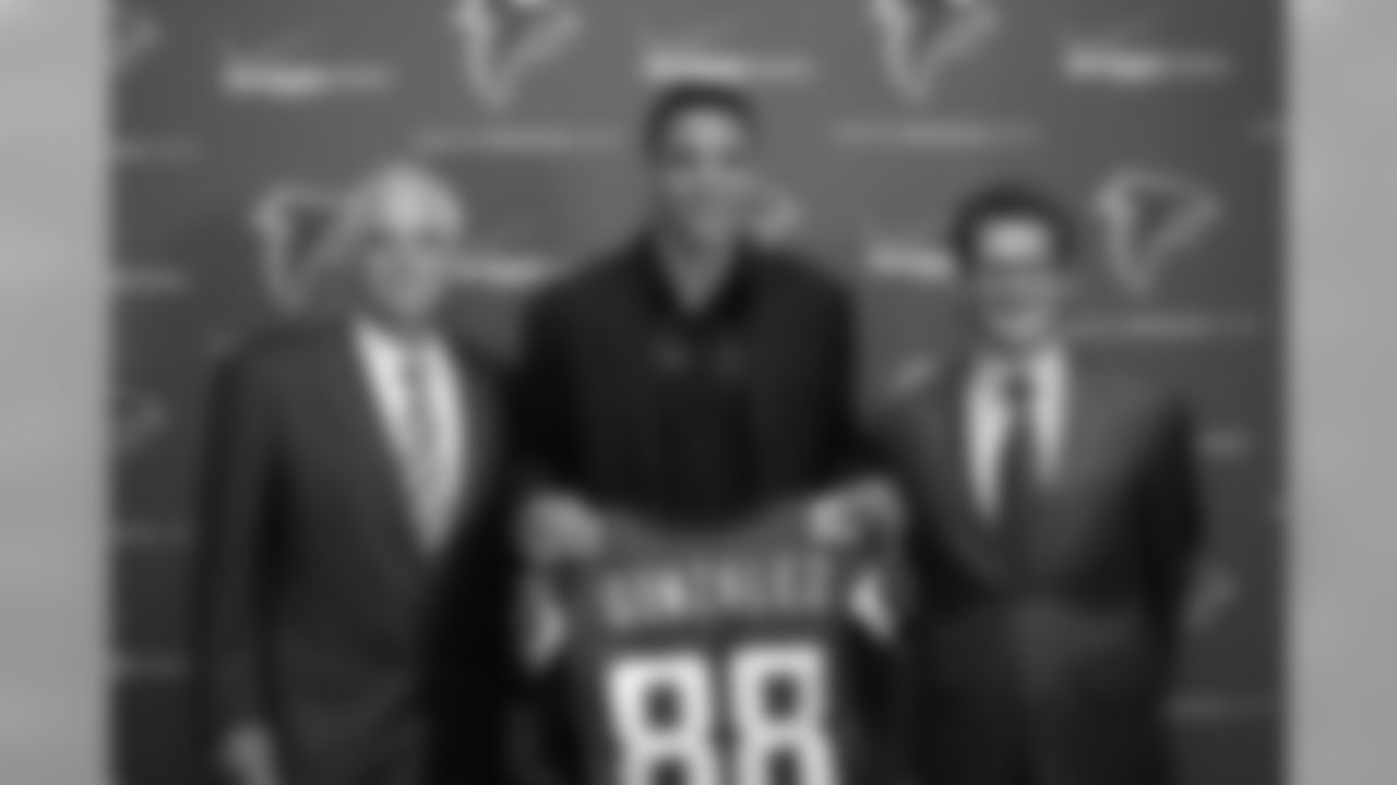 Tony Gonzalez holds up his new jersey in between head coach Mike Smith and general manager Thomas Dimitroff.