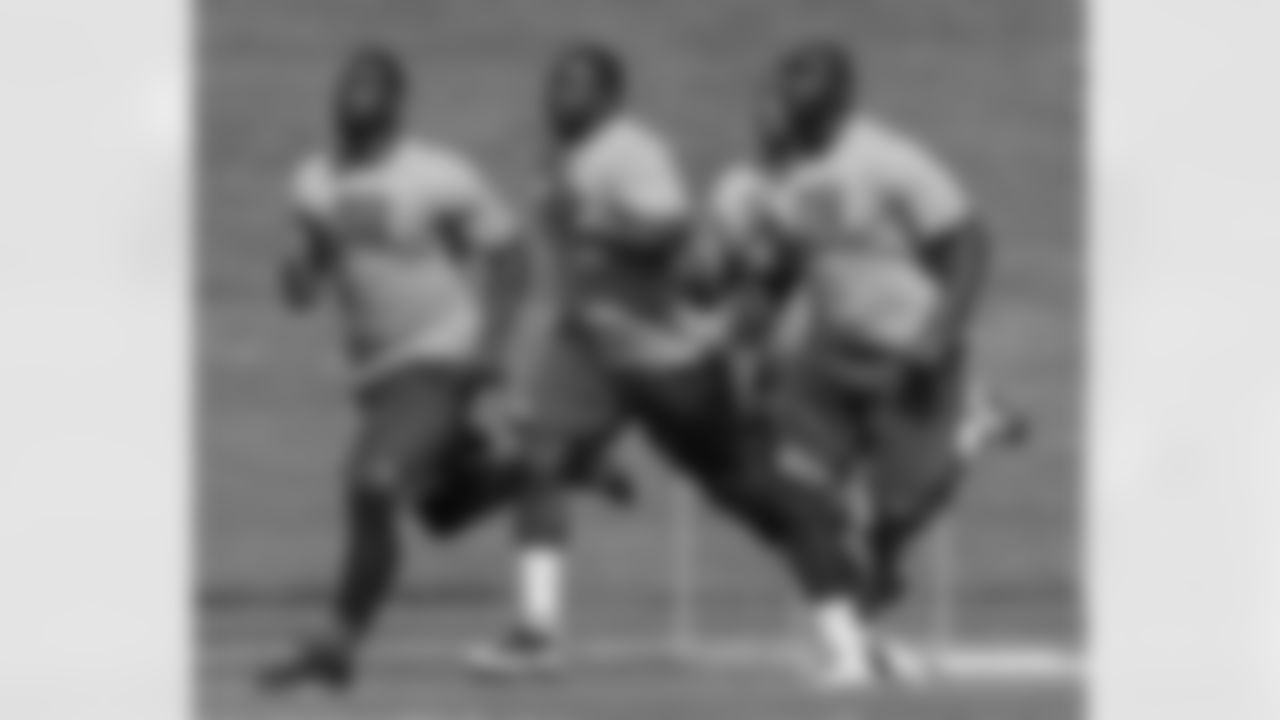 From left to right, New York Giants defensive end Justin Tuck, defensive tackle Dwayne Hendricks, and Adewale Omojo run through a physical evaluation drill on opening day of NFL football training camp in Albany, N.Y., Thursday, July 26, 2012. (AP Photo/Kathy Willens)