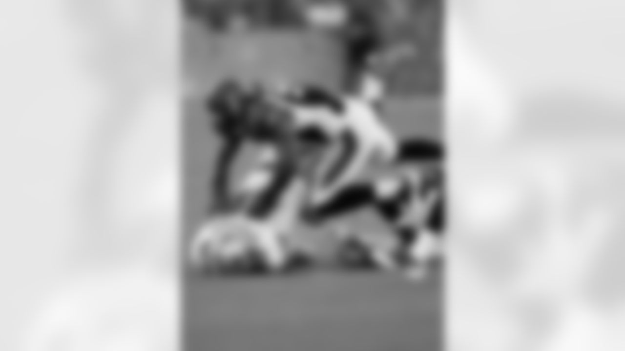 Cincinnati Bengals linebacker Keith Rivers (59) drives Dallas Cowboys tight end John Phillips (89) into the ground after the latter catches a pass during the NFL Pro Football Hall of Fame preseason football game between the Cowboys and the Bengals.