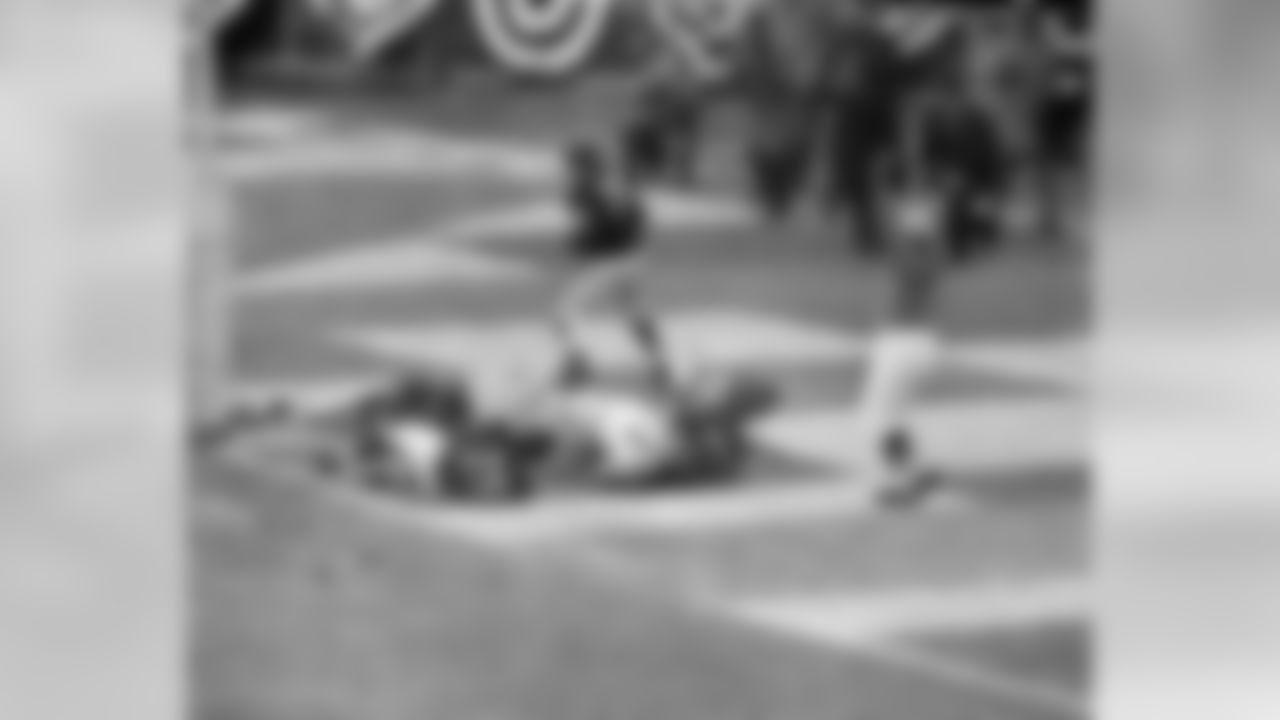 Giants' Mel Triplett (33) picks up a block and then charges past Chicago Bears players and over umpire Sam Wilson for 17 yards and a touchdown - first of the game - at Yankee Stadium in New York City, Dec. 30, 1956. Giants routed Bears 4707 to take the NFL championship. Identifiable players are: Alex Webster (29), Stan Wallace (40). (AP Photo/Harry Harris)