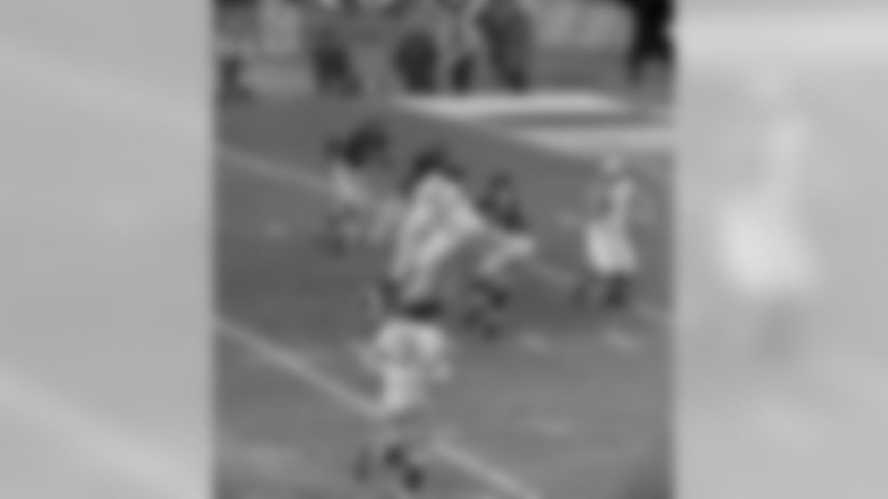 Giants' Mel Triplett (33) picks up a block and then charges past Chicago Bears players and over umpire Sam Wilson for 17 yards and a touchdown - first of the game - at Yankee Stadium in New York City, Dec. 30, 1956. Giants routed Bears 4707 to take the NFL championship. Identifiable players are Ed Meadows (86), Roosevelt Brown (79), Jack Stroud (66), Alex Webster (29), Joe Fortunato (31), Wayne Hansen (51), Stan Wallace (40), McNeil Moore (29), Ray Smith (20) and J.C. Caroline. (AP Photo/Harry Harris)