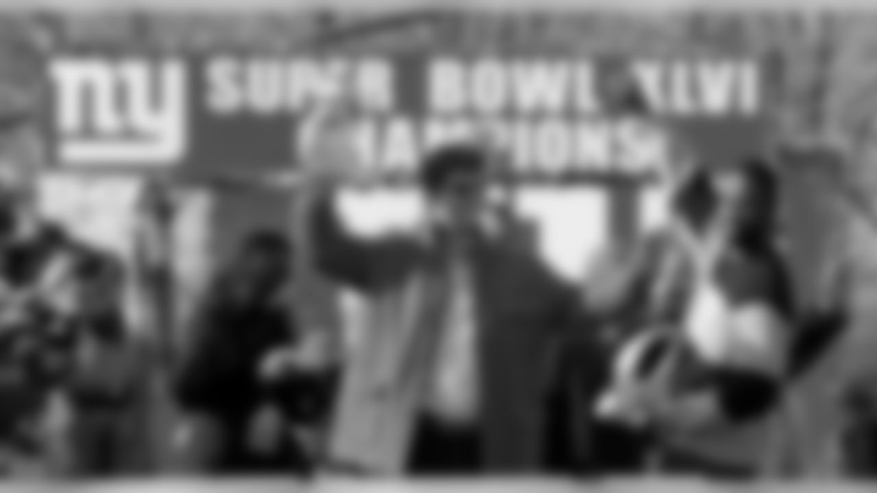 New York Giants quarterback Eli Manning, center, holding the Vince Lombardi Trophy and defensive end Justin Tuck, right, holding the Halas Trophy, wave to the crowd during a ticker-tape parade celebrating the team's NFL Super Bowl XLVI championship, Tuesday, Feb. 7, 2012, in New York. The Giants beat the New England Patriots 21-17 on Sunday, Feb. 5, in Indianapolis. (AP Photo/Julio Cortez)