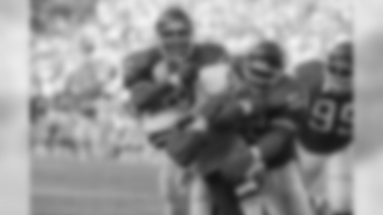 Washington Redskins running back Earnest Byner (21) is tackled by New York Giants defenders Lawrence Taylor (56) and Pepper Johnson (52) during first quarter NFL action at RFK Stadium in Washington, D.C., Sunday, Oct. 14, 1990. (AP Photo/Doug Mills)