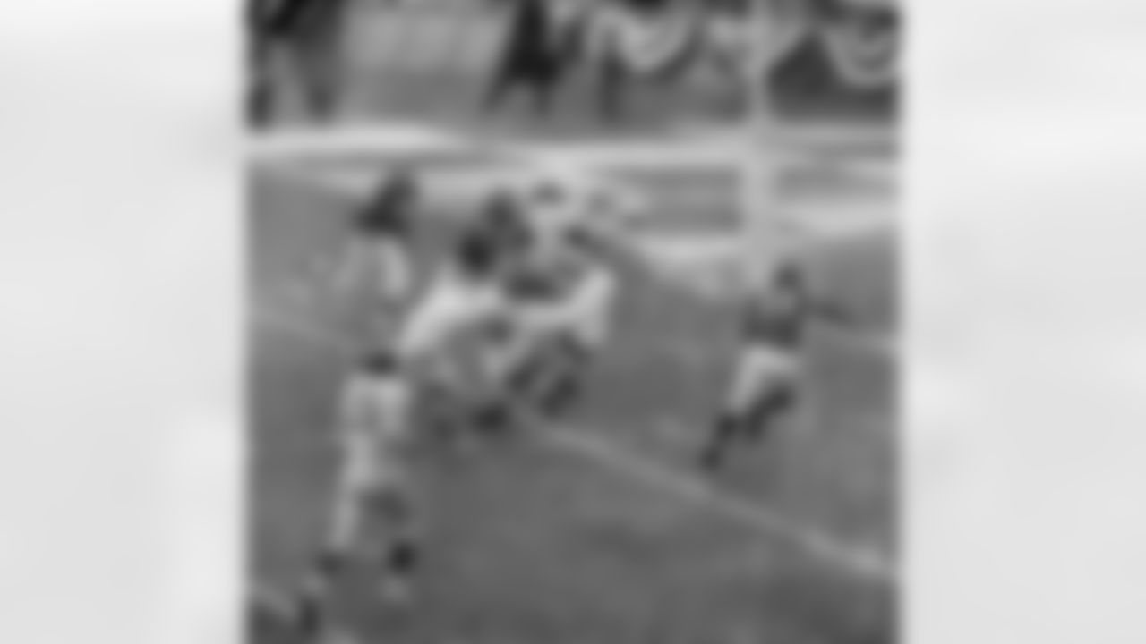 Giants' Mel Triplett (33) picks up a block and then charges past Chicago Bears players and over umpire Sam Wilson for 17 yards and a touchdown - first of the game - at Yankee Stadium in New York City, Dec. 30, 1956. Giants routed Bears 47-7 to take the NFL championship. Identifiable players are: Jack Stroud (66), Alex Webster (29), Stan Wallace (40), McNeil Moore (29), and J.C. Caroline. (AP Photo/Harry Harris)
