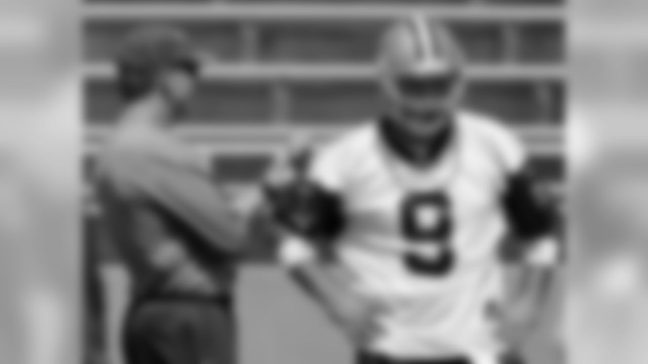 Dallas Cowboys offensive coordinator Jason Garrett, left, relays a play to quarterback Tony Romo (9) during a practice session at the NFL football team's minicamp in Carrollton, Texas, Tuesday, June 16, 2009. (AP Photo/Tony Gutierrez)