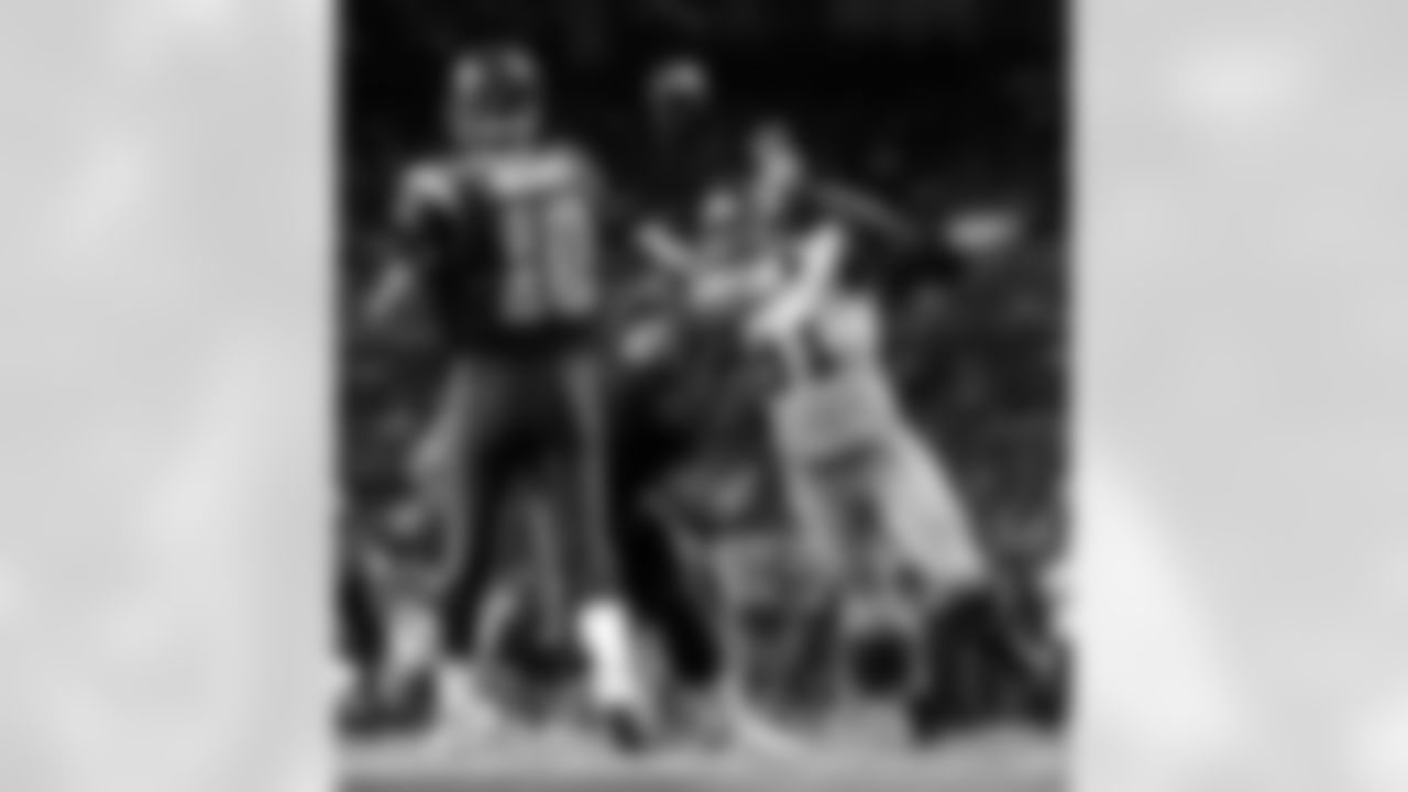 St. Louis Rams quarterback Marc Bulger (10) completes a pass under pressure from New York Giants defensive end Justin Tuck (91) as Rams' Richie Incognito (68) holds Tuck back during the fourth quarter of an NFL football game Sunday, Sept. 14, 2008, in St. Louis. (AP Photo/Jeff Roberson)