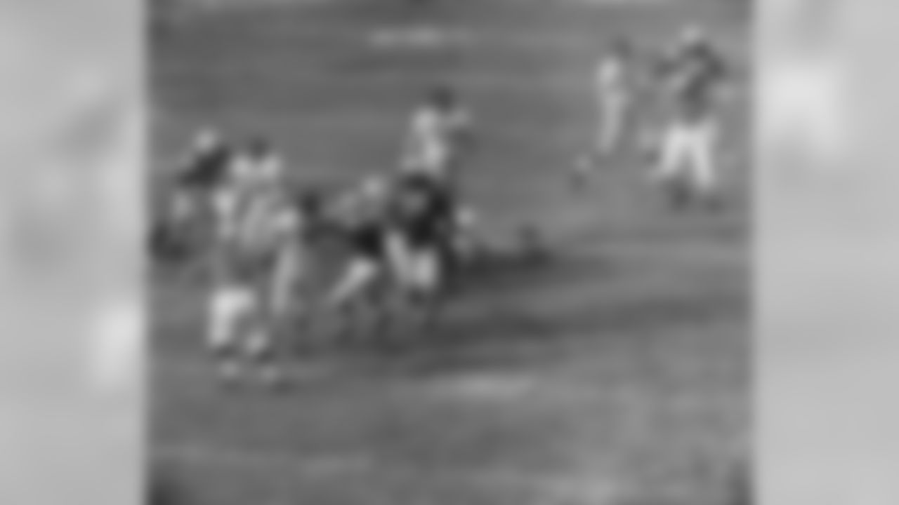 Charles Conerly, 42, New York Giants' quarterback, is grabbed by Gino Marchetti, Baltimore Colts' end, as he tries to pass in the first period on Dec. 27, 1959 in Baltimore. Cornerly couldn't get the ball away and was dropped for a 20 yard loss. No. 76 at right is Gene Lipscomb of the Colts. (AP Photo)