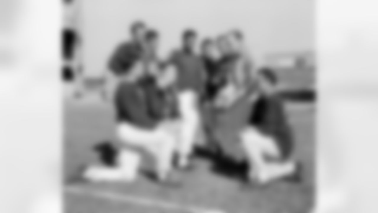 Defensive backfield coach Tom Landry holds ball as New York Giant defense men huddle Nov. 6, 1958 during workout at Yankee stadium in New York City. They will be called on Nov. 9 to stop the passing and running attack of the undefeated baltimore colts. From left to right are; kneeling, linebacker Harland Svare, middle guard Sam Huff and back Cliff Livingston. Standing, backs Carl Karilivacz, Jim Patton, Em Tonnell, Linebacker Bill Svoboda, back Lindon crow and landry. (AP Photo/John Lindsay)