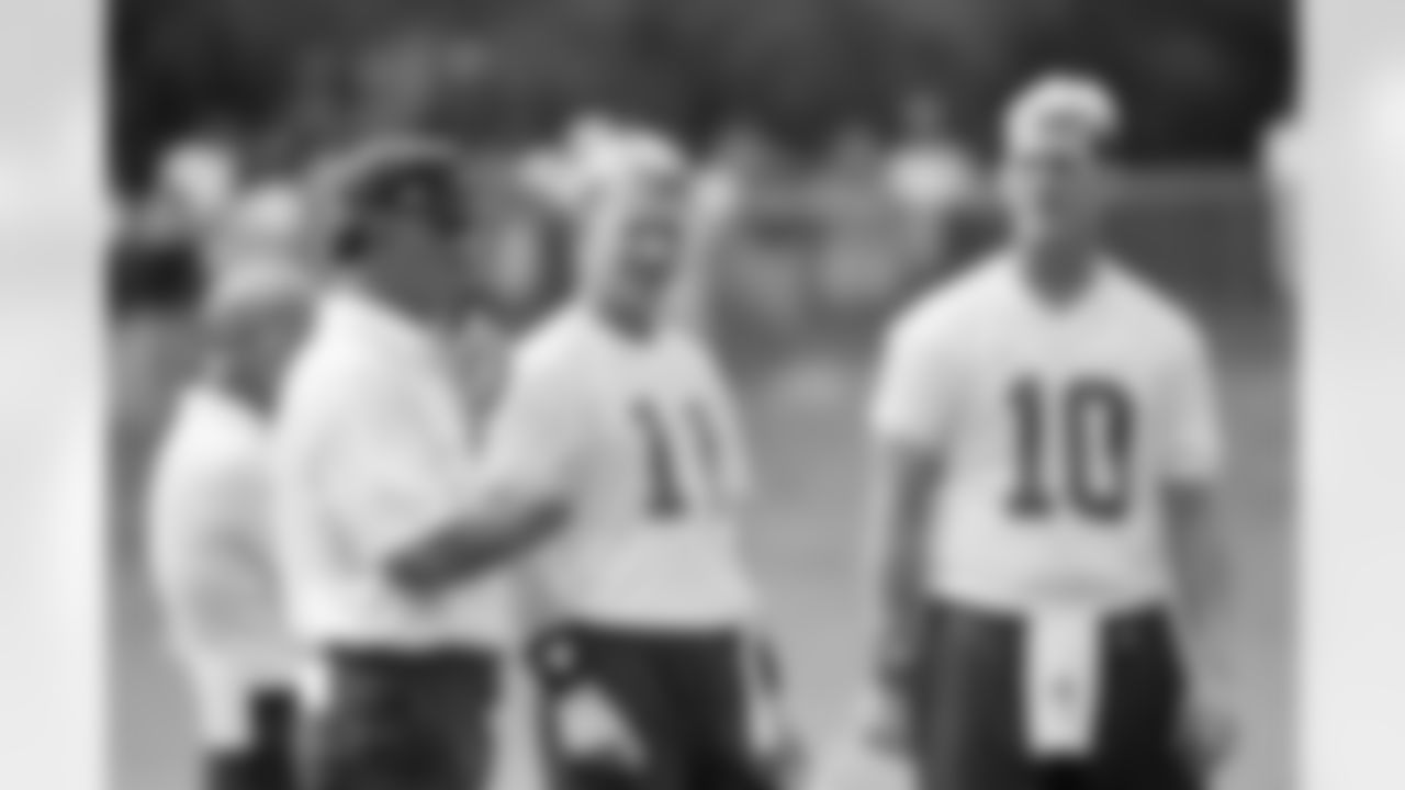 New York Giants quarterback Phil Simms (11) and Kent Graham (10) watch head coach Dan Reeves, left, signal, in a play during morning practice at training camp in Madison, N.J. Aug. 13, 1993. (AP Photo/Daniel Hulshizer)