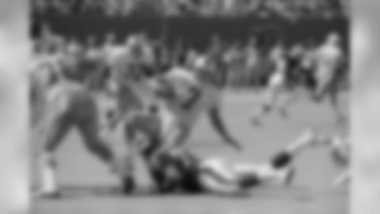Tampa Bay Buccaneers quarterback Craig Erickson (7) loses his balance as New York Giants Erik Hamilton applies pressure during the first quarter of their match at Giants Stadium in East Rutherford, New Jersey, Sept. 12, 1993. The Giants downed the visiting Buccaneers 23-7. (AP Photo/Mark Lennihan)