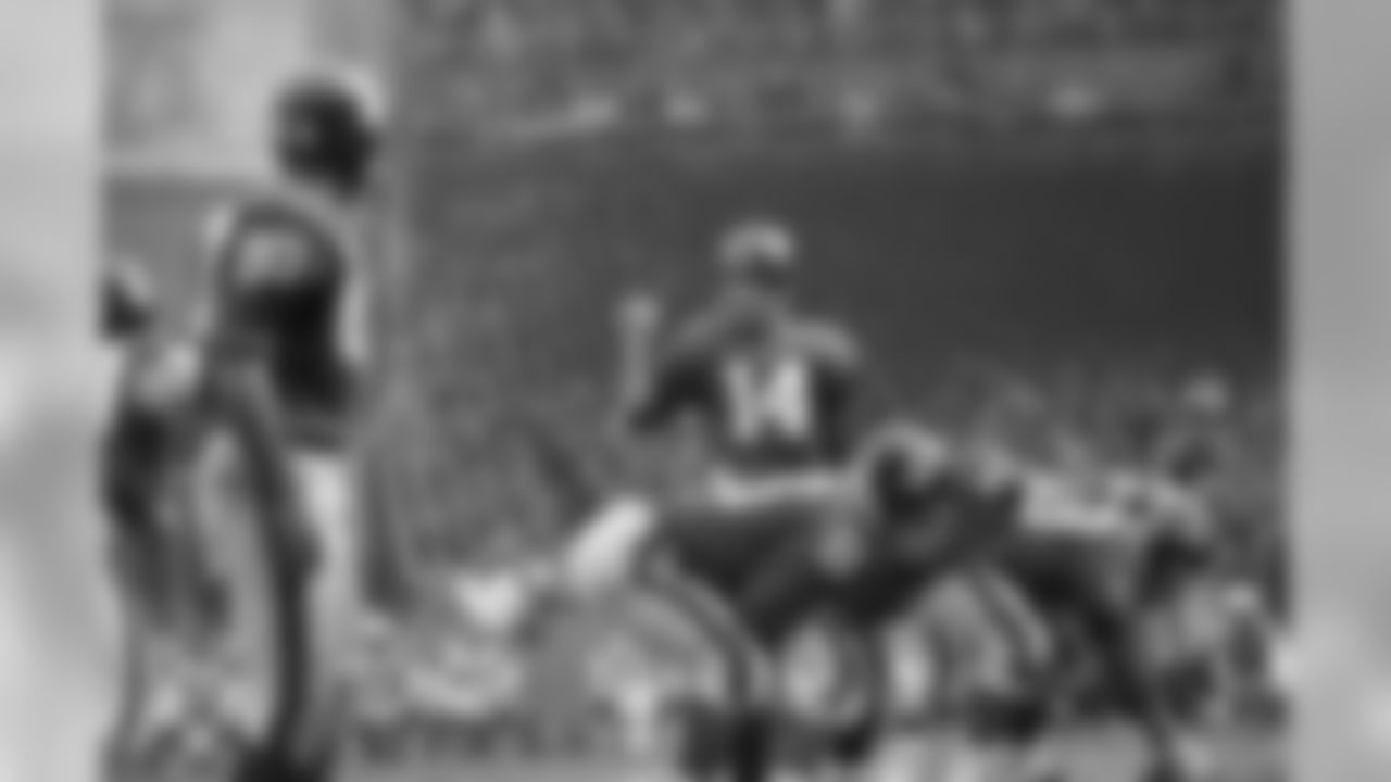 Y.A. Tittle, quarterback of the N.Y. Giants, directs a last minute shift in strategy as the Giants line crouches to engage the Dallas Cowboys, Nov. 12, 1963. (AP Photo/Ruben Goldberg)