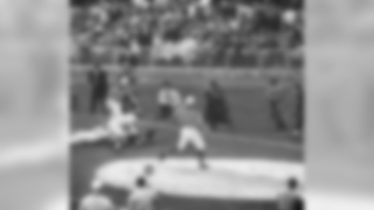 The ball spurts from the hands of New York Giants Bob Gaiters (35), top, after taking a handoff from quarterback Y.A. Tittle (14) in the third period of a game with the Philadelphia Eagles at Yankee Stadium, Nov. 12, 1961, New York. The touchdown is made despite efforts of Eagles Jimmy Carr, (21) and Bob Freeman (41) to haul him off. Giants won 38-21. The rest of the players are unidentified. (AP Photo)