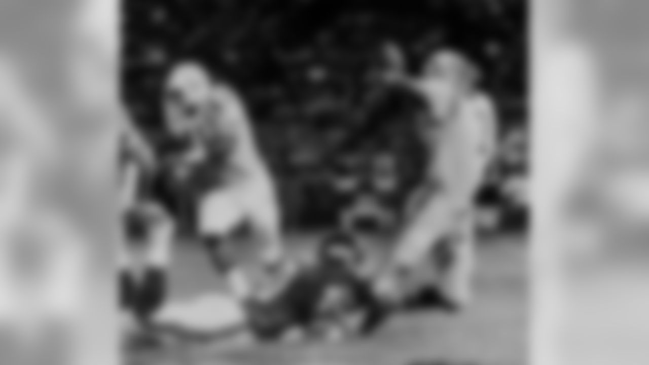 Gary Jeter, defensive end for the New York Giants, dives to the ground and brings down quarterback Bert Jones of the Baltimore Colts as he gets off a pass in the first quarter of their NFL exhibition game in Baltimore, Md., Aug. 22, 1980. The Colt's running back Mark Bailey (41) races to block another Giant defender, as Jones' pass fell incomplete in the end zone. (AP Photo/Joe Giza)