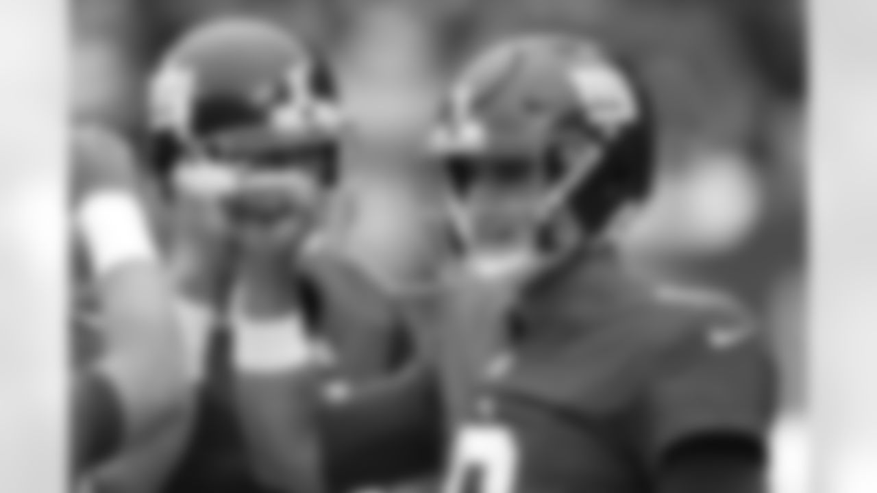 New York Giants quarterback Daniel Jones, right, talks to teammates before an NFL preseason football game against the New England Patriots Sunday, Aug. 29, 2021, in East Rutherford, N.J. (AP Photo/Noah K. Murray)