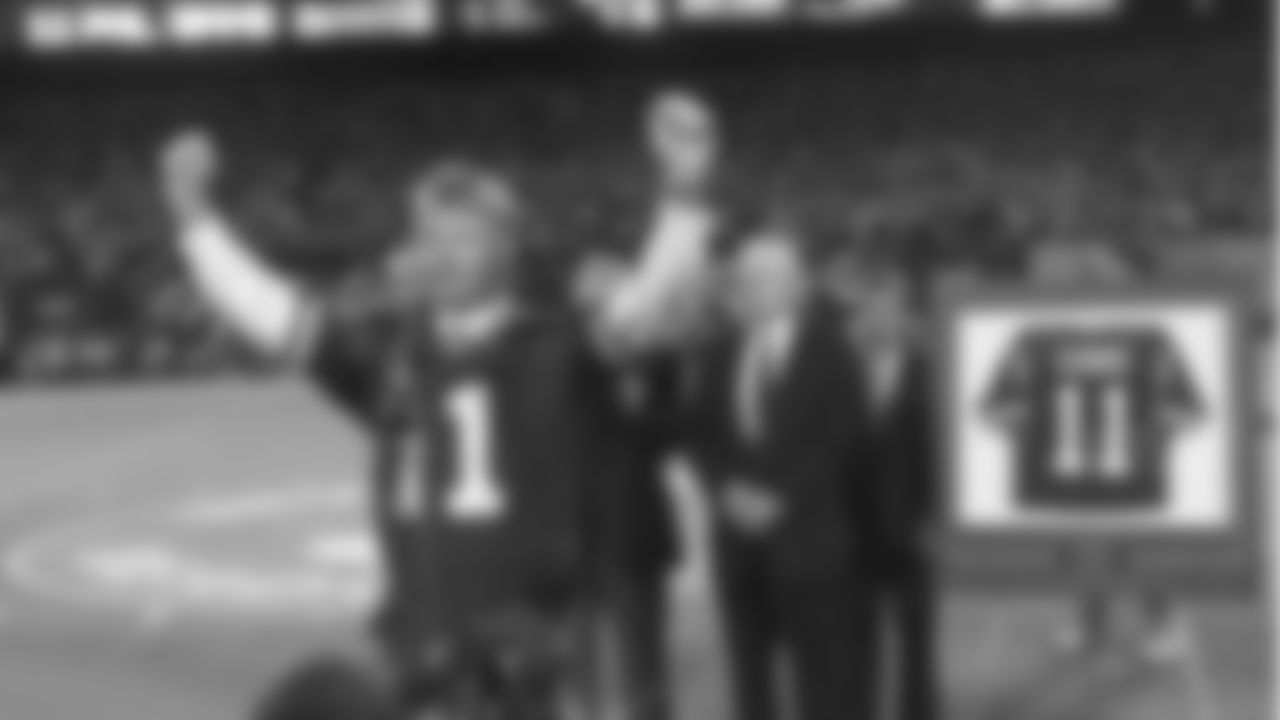 Former New York Giants quarterback Phil Simms lifts his arms to the crowd after his number was retired by Giants President Wellington Mara, center, during halftime ceremonies in Giants Stadium in East Rutherford, N.J., Monday, Sept. 4, 1995. (AP Photo/Charles Rex Arbogast)
