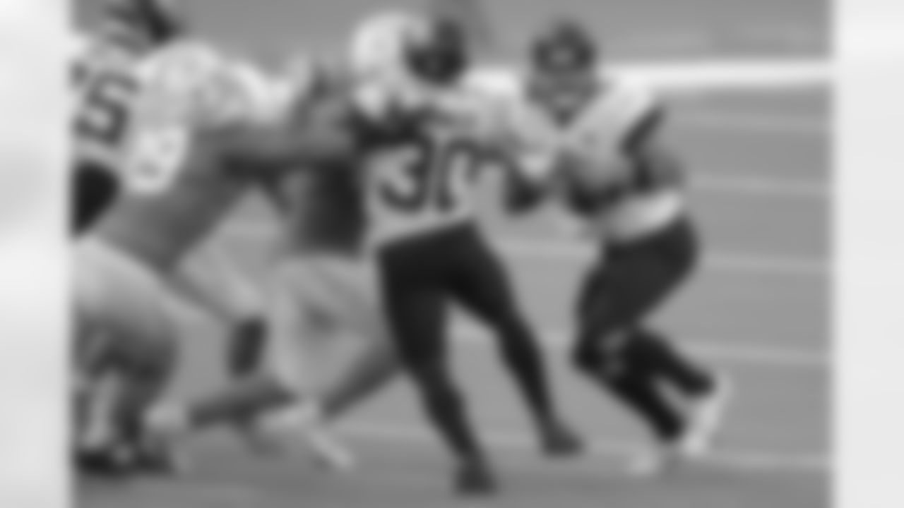 Jacksonville Jaguars rookie running back James Robinson (30) single-handedly holds back three Los Angeles Chargers allowing quarterback Gardner Minshew II (15) to escape a sack during an NFL football game, Sunday, Oct. 25, 2020 in Inglewood, Calif.
