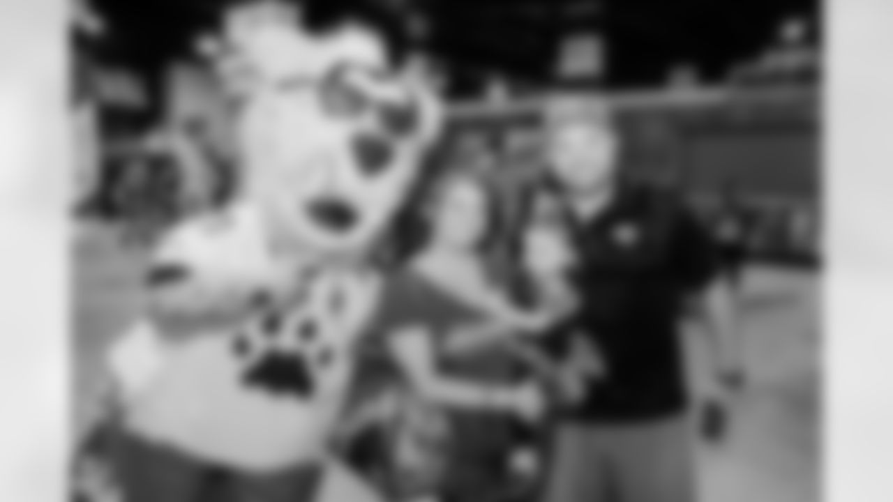A family of Jaguars fans poses with Jaxson at the Tour and Treat season ticket member event for Halloween.
