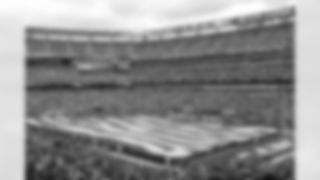 Military members unfurl a 100-yard long American Flag as the fans lead the singing of the National Anthem.