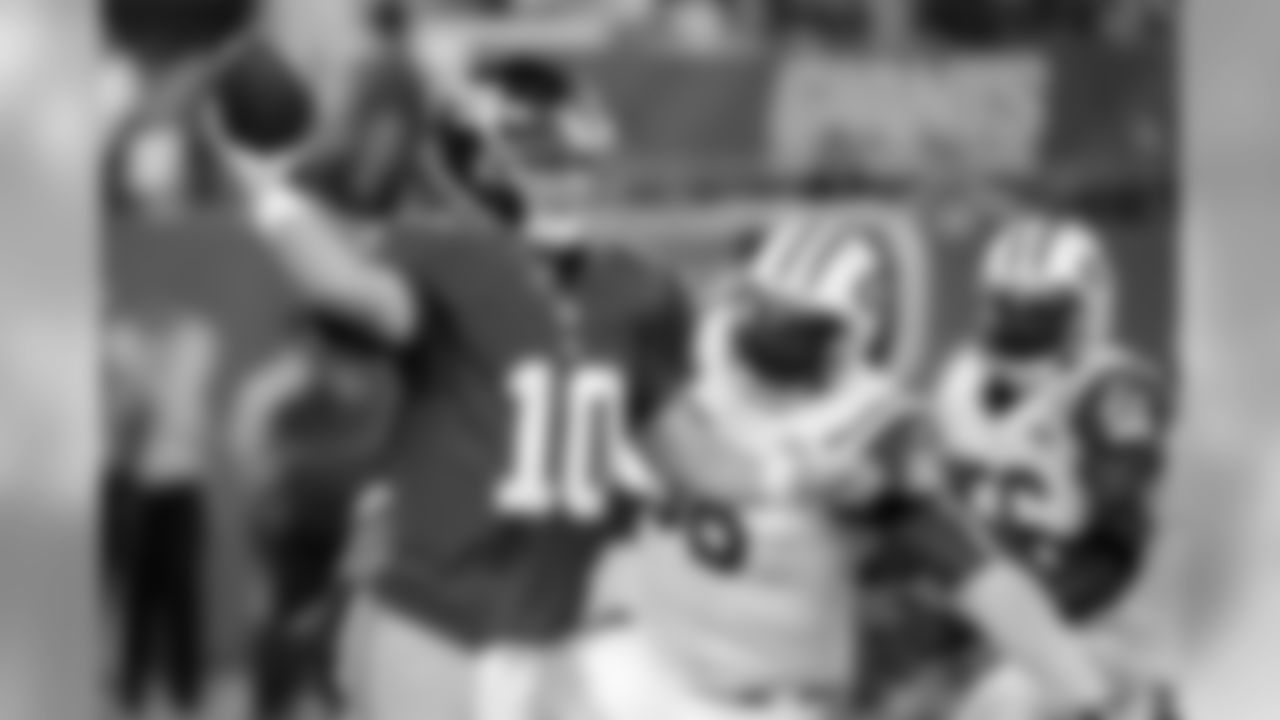 Giants QB Eli Manning (10) is forced to throw away a pass by DE Muhammad Wilkerson (96) and LB Demario Davis (56) during the first half of the preseason game.