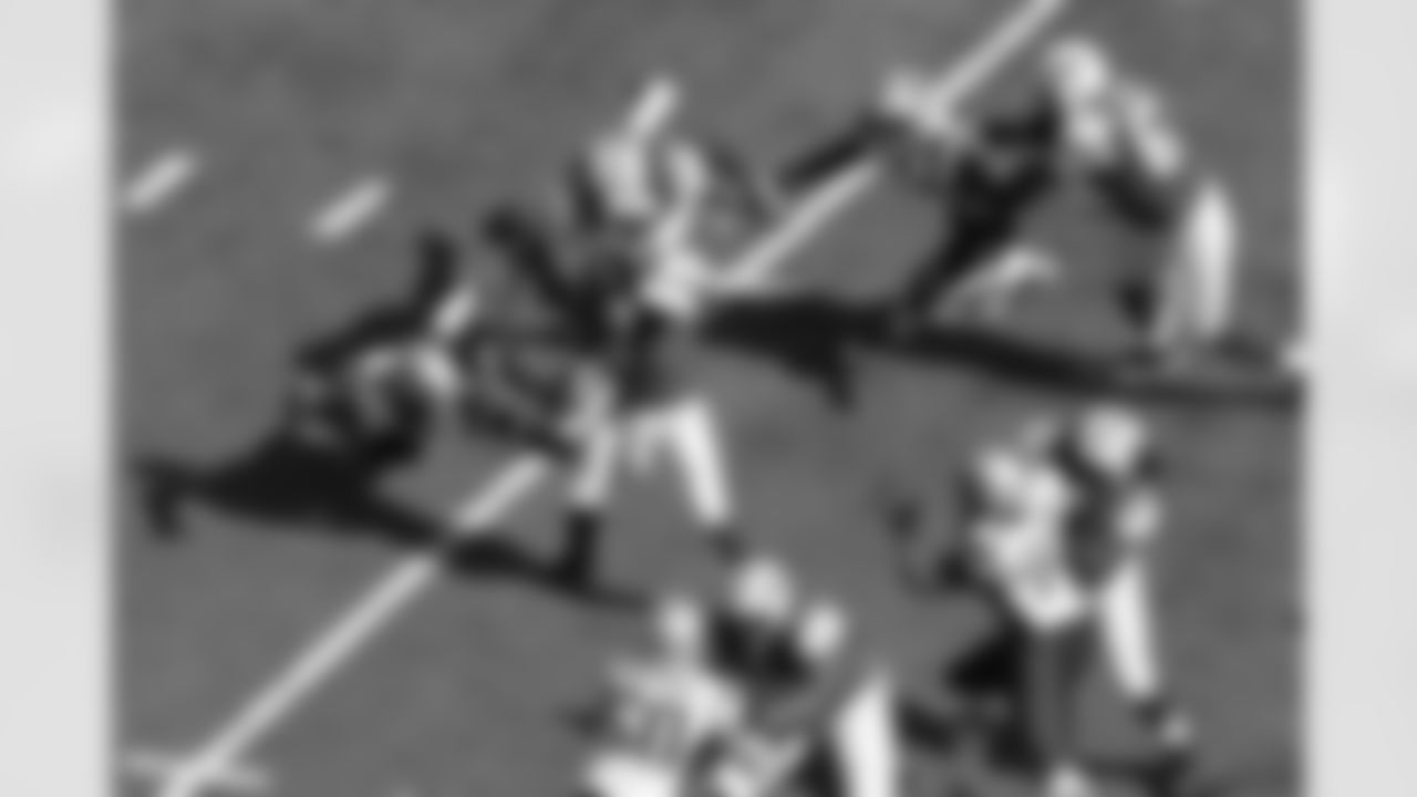Smith, surrounded by defenders, throws a pass against the New England Patriots.