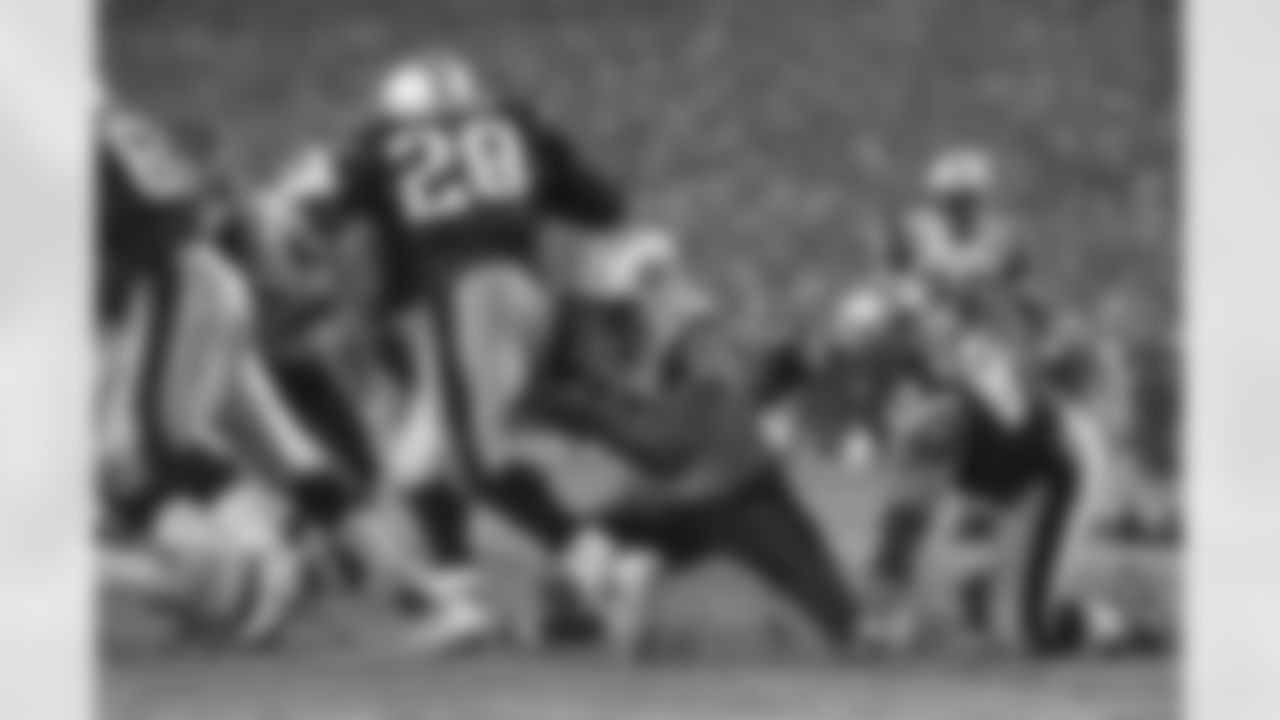 DE John Abraham (No. 56) attempts to tackle RB Corey Dillon from his knees during the 16-3 loss in Foxborough, Mass., 12/4/05.