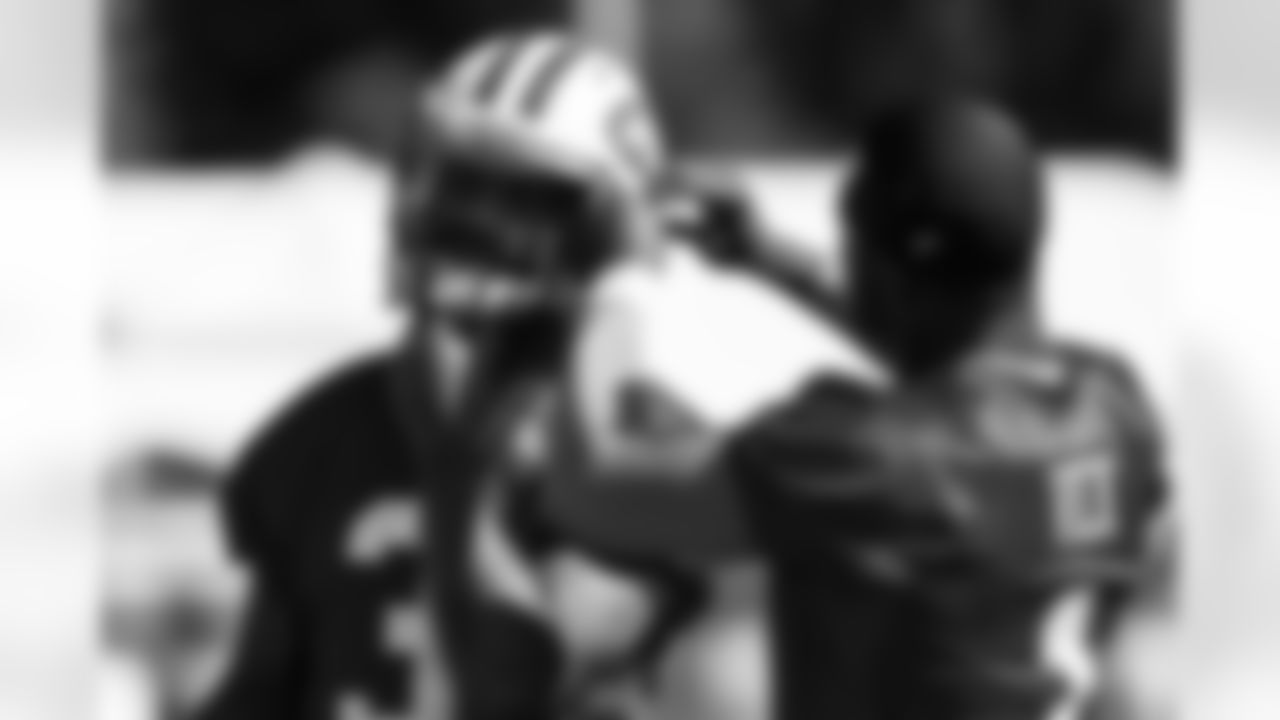 Embracing his role as a veteran on the team, QB Michael Vick, right, helped rookie QB Tajh Boyd with his chin strap on the first day of training camp.